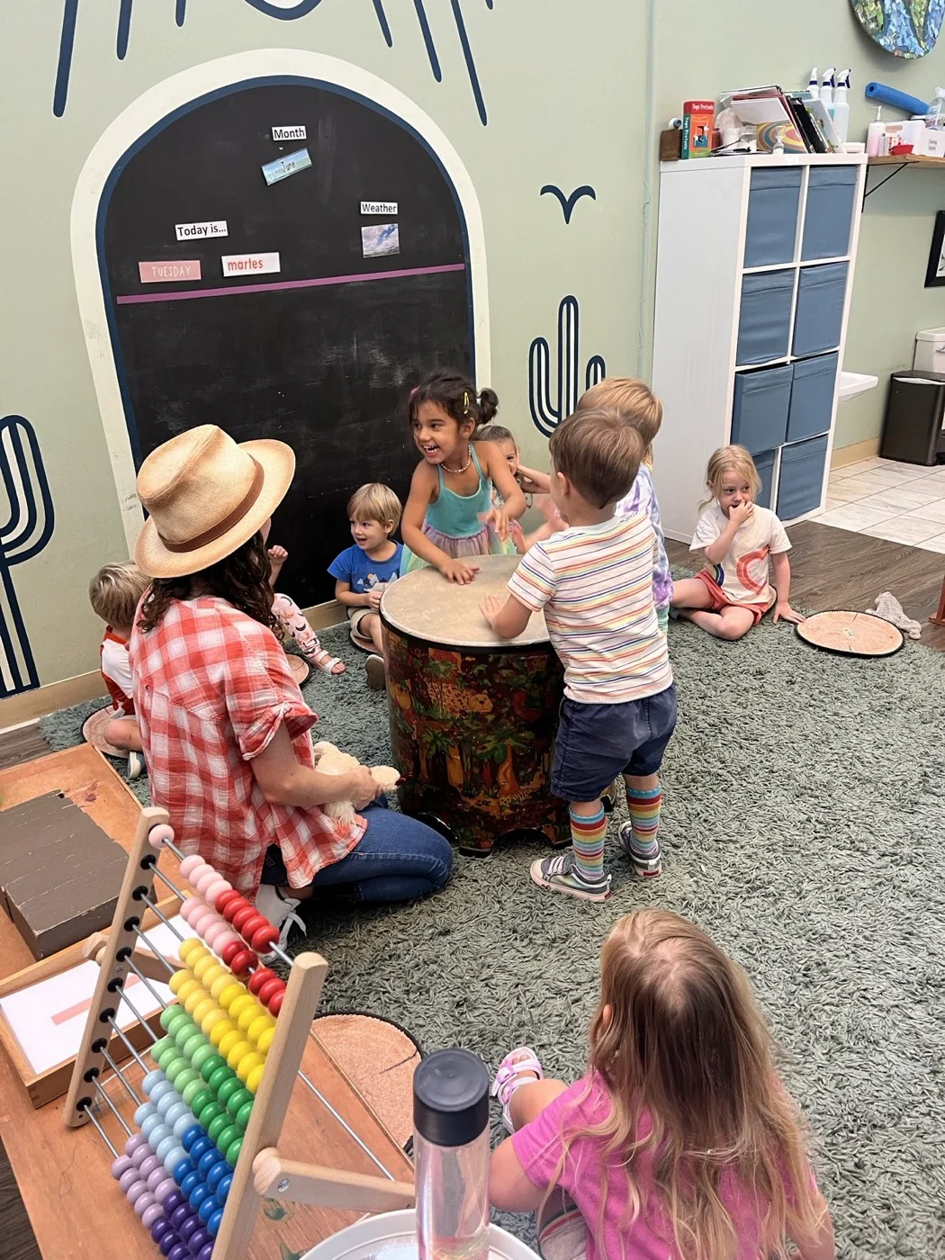 Children gathered around a hand drum in a music class